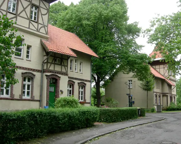Fachwerkhäuser in der alten Kolonie Eving, umgeben von üppigem Grün und Bäumen.