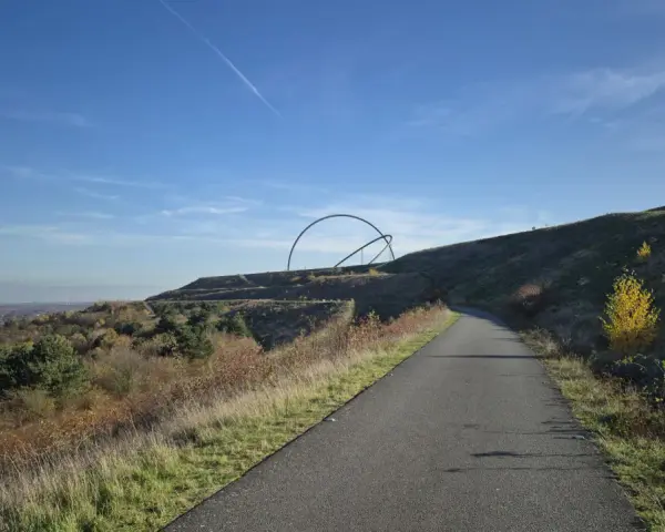 Weg zur Halde Hoheward mit der markanten Skulptur "Himmelspiegel" im Hintergrund.