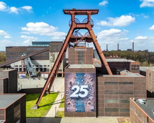 Große Fördergerüst-Struktur auf dem Gelände der Zeche Zollverein, die eine Ausstellung mit der Zahl 25 feiert.