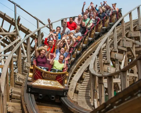 Menschen jubeln auf der Holzachterbahn "Wodan" im Europa-Park. Die rasante Fahrt sorgt für pure Freude und Adrenalin.