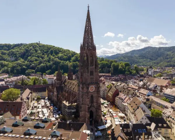 Blick auf den Freiburger Münsterplatz mit Marktständen. Hier kann man in Freiburg viel entdecken, von der beeindruckenden Architektur bis zum lebhaften Treiben.
