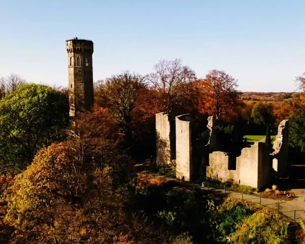 Herbstliche Szene mit dem alten Turm und Ruinen der **Dortmund Syburg** im warmen Licht.