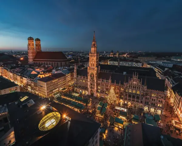 Beleuchtetes Rathaus und Christkindlmarkt in München, ein perfekter Ort für Munich Sightseeing bei Nacht.