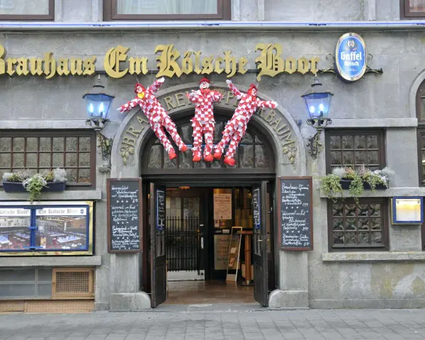 Drei Clowns hängen vor dem Brauhaus Em Kölsche Boor. Wann wird der Nubbel verbrannt? Bald, wenn die Karnevalszeit beginnt!