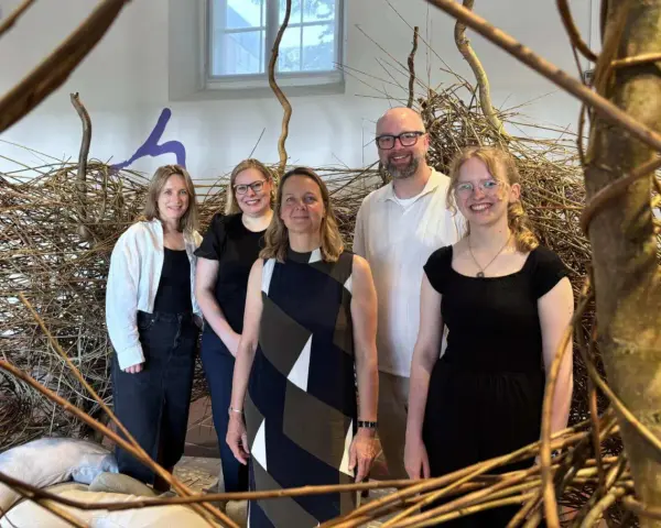 Fünf Personen stehen vor einer Installation aus Ästen. Sie sind Teil des museumsnacht programm.