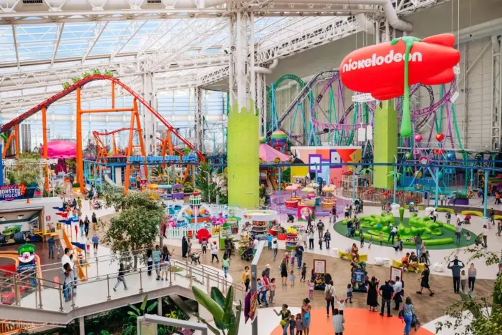 Buntes Treiben im Nickelodeon Park Deutschland mit Achterbahnen, Fahrgeschäften und vielen Besuchern.