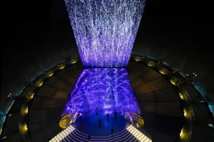 Im Gasometer Oberhausen erstrahlt eine Projektion aus tausenden Lichtpunkten, die wie ein Sternenhimmel oder ein Wasserfall wirken.