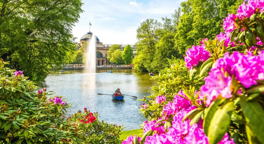 Bootsfahrt auf dem See mit Brunnen im Hintergrund – eine schöne Idee für Wiesbaden Unternehmungen.