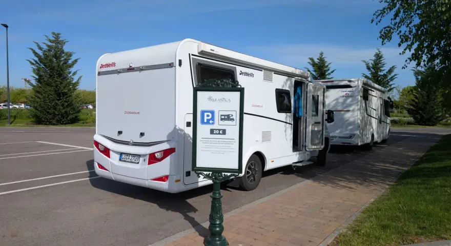 Wohnmobile parken am Europapark. Ein Schild weist auf die Parkgebühr von 20 € für Rulantica hin.