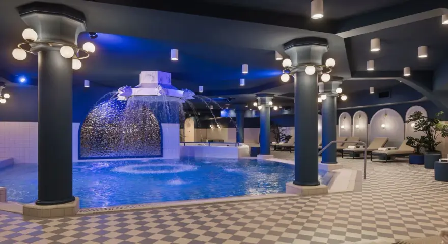 Ein luxuriöses Schwimmbad im Efteling-Stil mit Wasserspielen und Entspannungsbereichen.