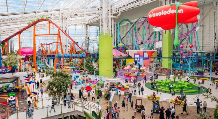 Buntes Treiben im Nickelodeon Park Deutschland mit Achterbahnen, Fahrgeschäften und vielen Besuchern.