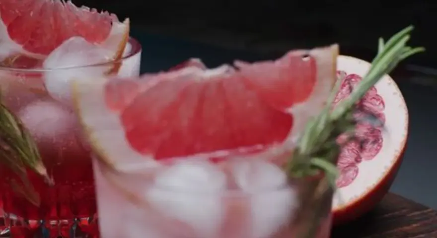 Erfrischende sommer drinks mit tonic water, Eiswürfeln und Grapefruit-Garnitur. Ein Hauch Rosmarin rundet das Bild ab.