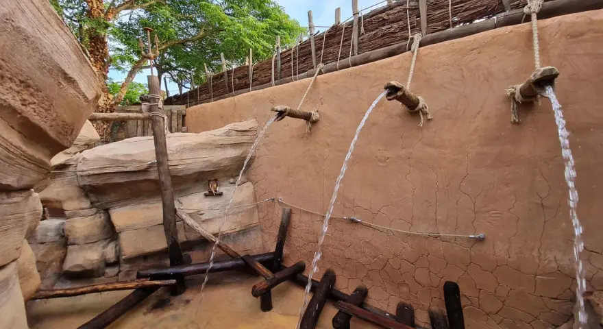 Wasserfälle speien auf einem Abenteuerpfad im Phantasialand. Holz und Felsen schaffen eine rustikale Atmosphäre.