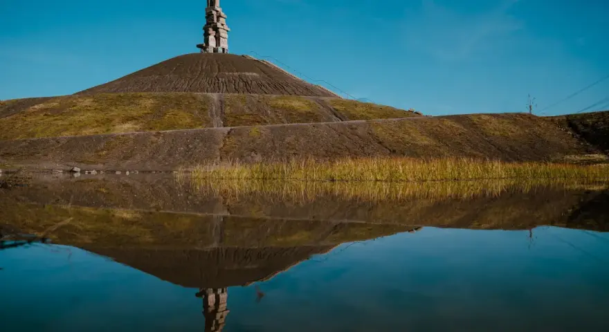 Die Himmelstreppe Gelsenkirchen spiegelt sich im Wasser. Ein Kunstwerk auf einer Halde.