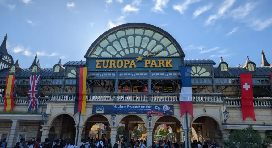 Einlass zum Europa-Park mit Fahnen und jubelnden Besuchern.