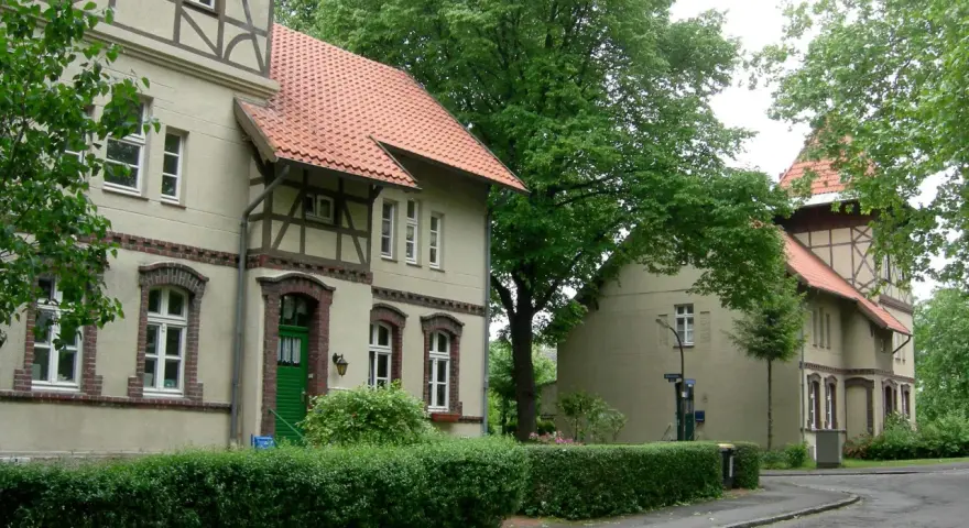 Fachwerkhäuser in der alten Kolonie Eving, umgeben von üppigem Grün und Bäumen.