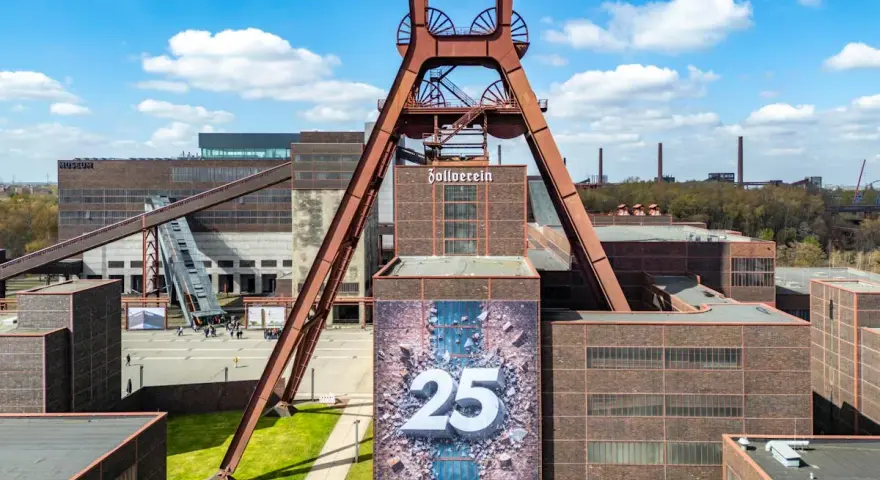Große Fördergerüst-Struktur auf dem Gelände der Zeche Zollverein, die eine Ausstellung mit der Zahl 25 feiert.