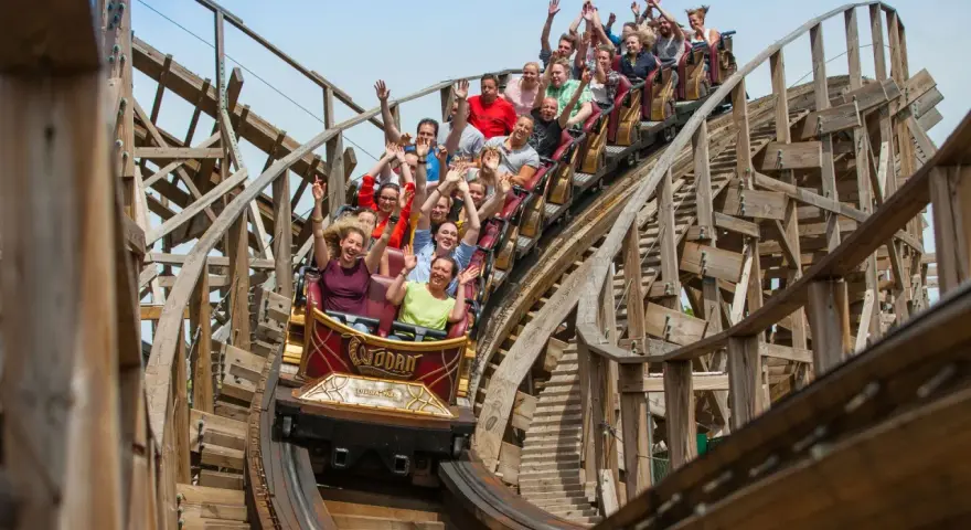 Menschen jubeln auf der Holzachterbahn "Wodan" im Europa-Park. Die rasante Fahrt sorgt für pure Freude und Adrenalin.