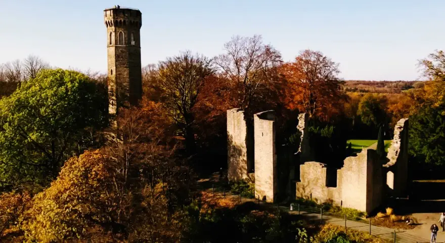 Herbstliche Szene mit dem alten Turm und Ruinen der **Dortmund Syburg** im warmen Licht.