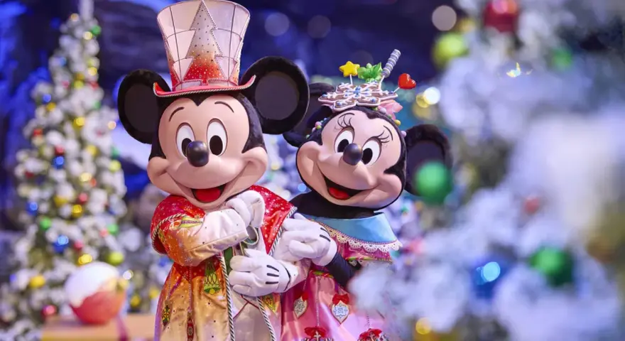 Mickey und Minnie in festlichen Outfits vor Weihnachtsbäumen im Disneyland. Ein magisches Weihnachtserlebnis!