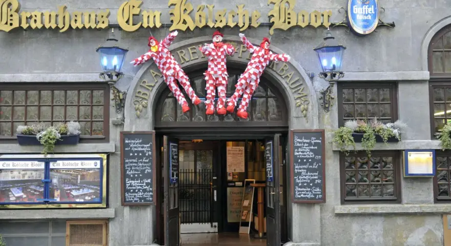 Drei Clowns hängen vor dem Brauhaus Em Kölsche Boor. Wann wird der Nubbel verbrannt? Bald, wenn die Karnevalszeit beginnt!