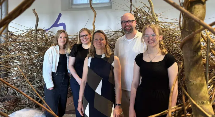 Fünf Personen stehen vor einer Installation aus Ästen. Sie sind Teil des museumsnacht programm.