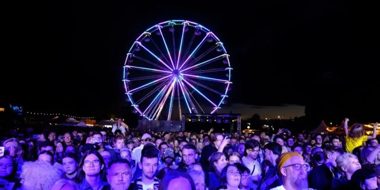 Buntes Riesenrad über einer jubelnden Menge bei Waltrop Veranstaltungen.