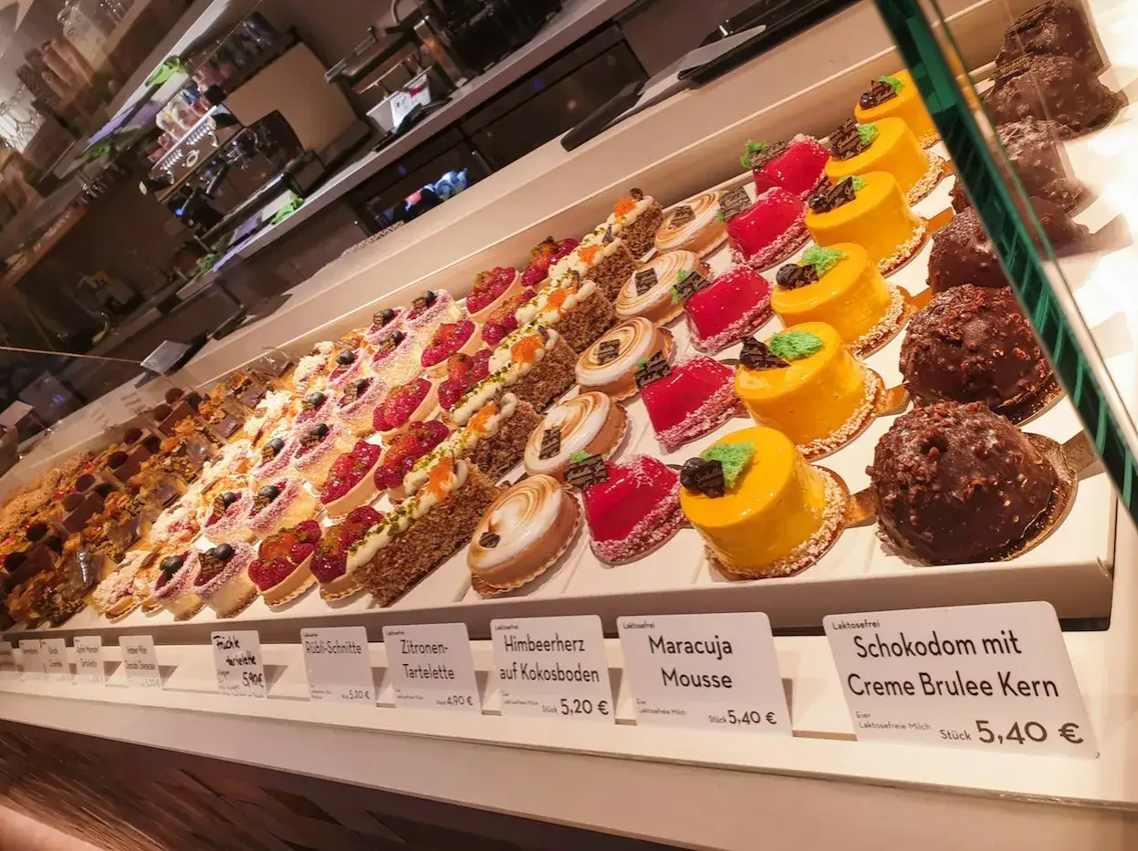Vielfalt an glutenfreien Leckereien bei Isabella Glutenfreie Pâtisserie: bunte Törtchen, Frucht- und Schokodesserts.