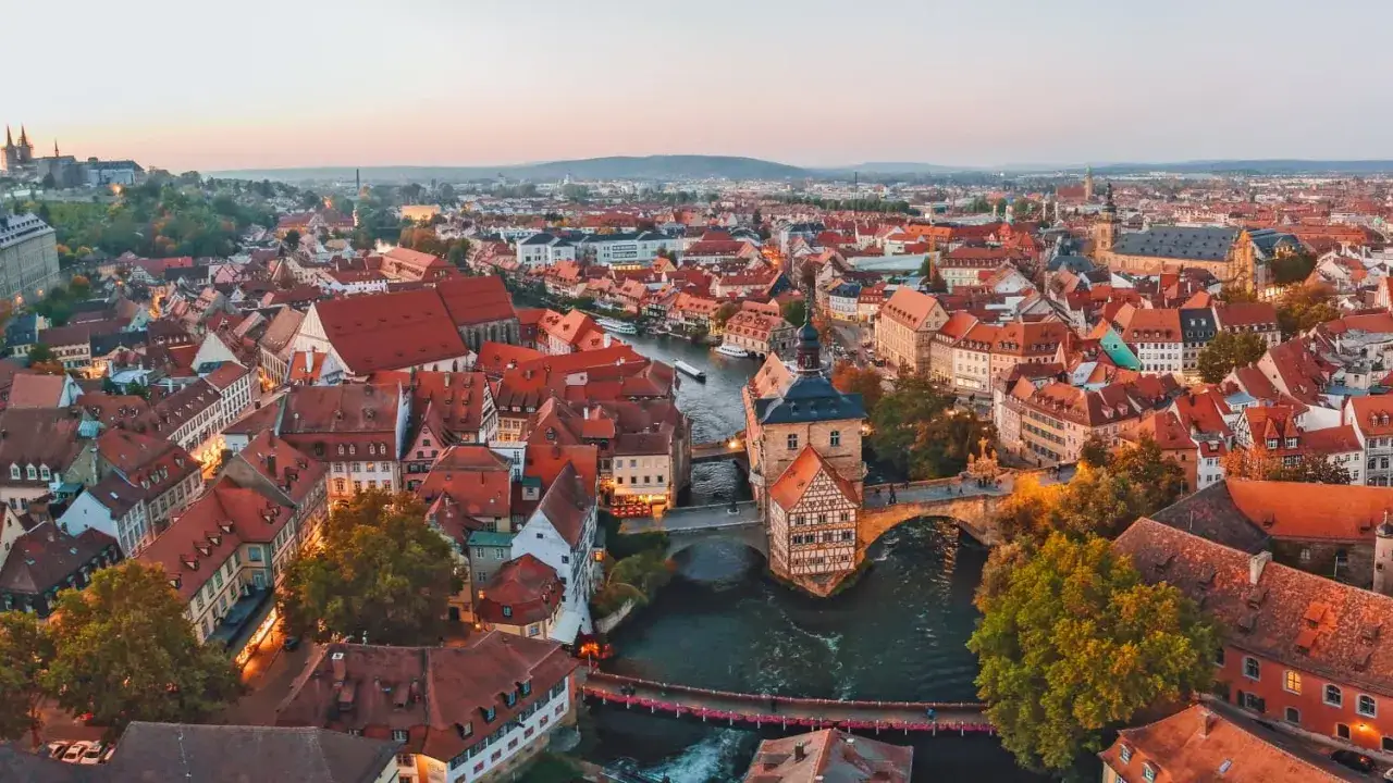 Blick &uuml;ber die malerische Bamberger Innenstadt mit ihren roten D&auml;chern und dem Fluss Regnitz. Das Alte Rathaus ragt stolz aus dem Wasser.