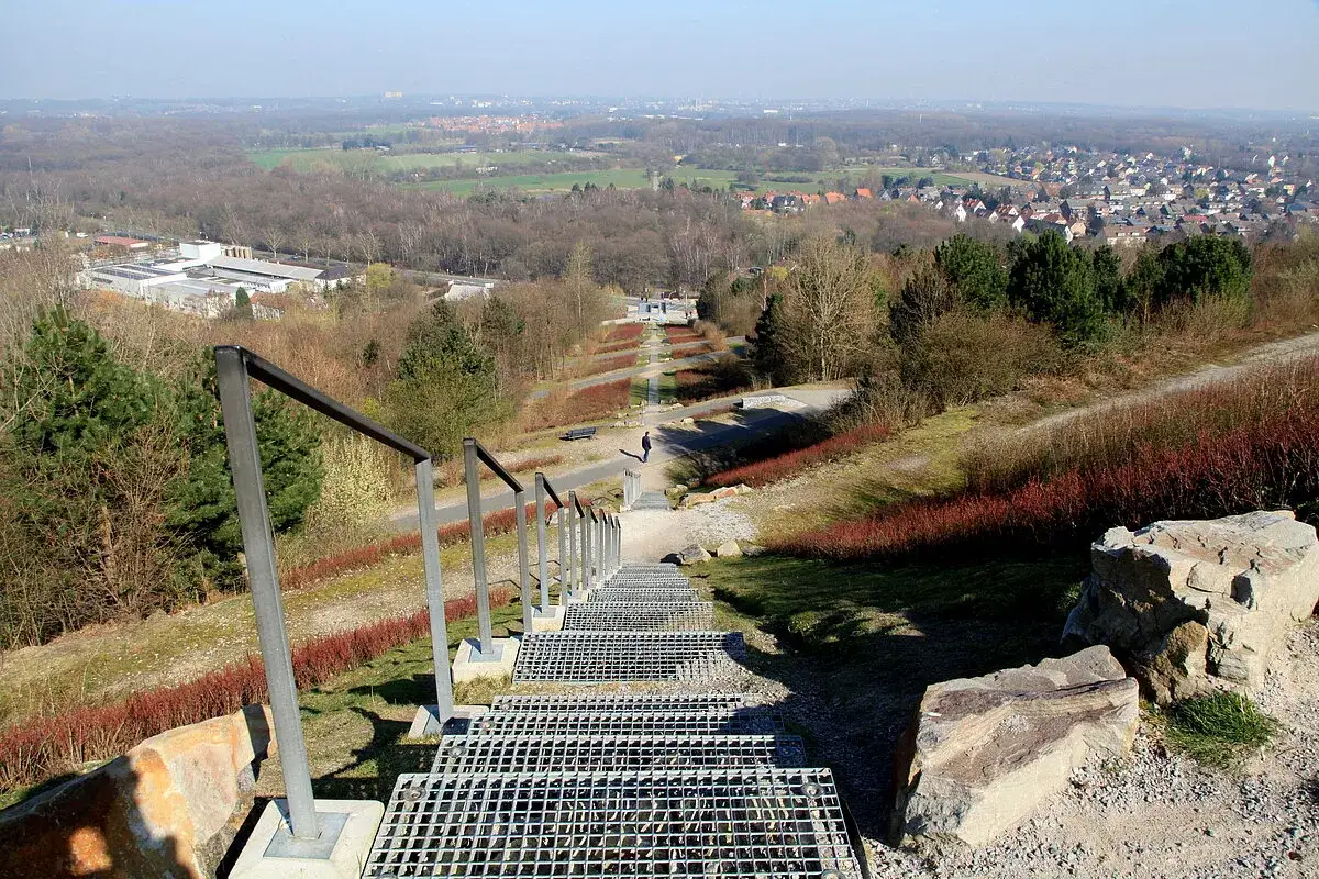 Treppe f&uuml;hrt hinab zur Halde Hoheward. Ein Spazierg&auml;nger genie&szlig;t die Aussicht &uuml;ber die Landschaft.