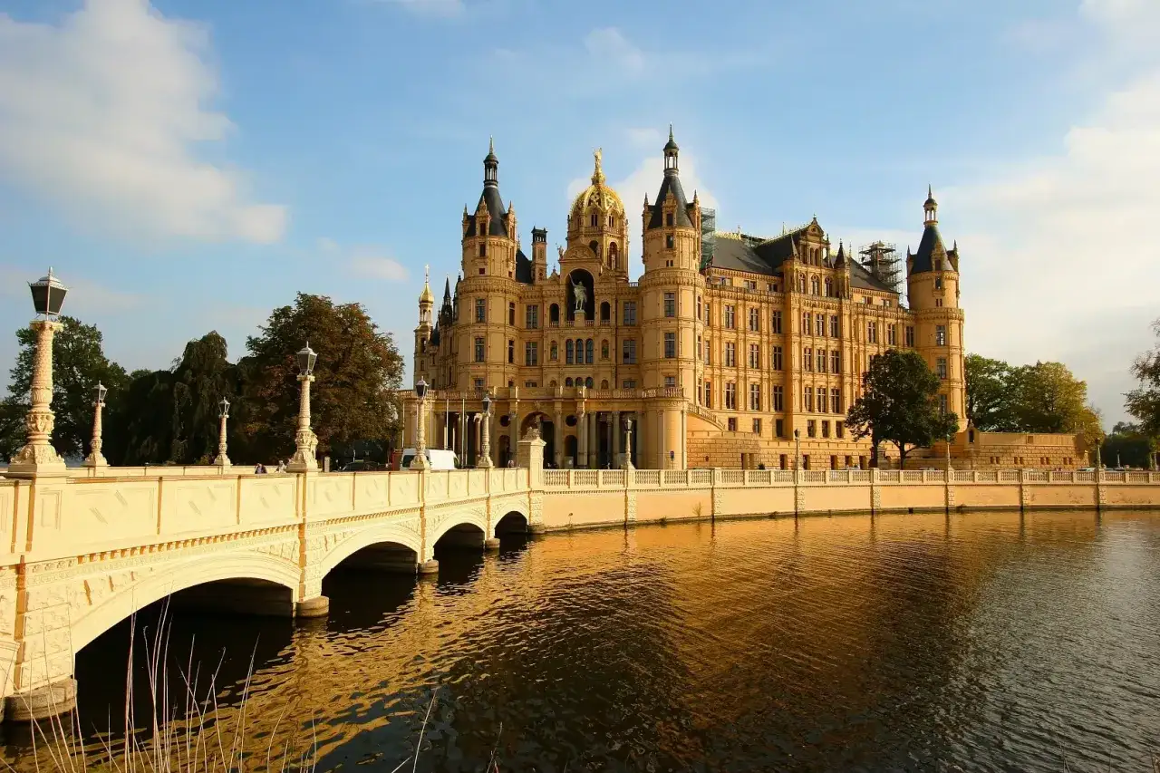 Schweriner Schloss mit Brücke und Wasser. Ein Märchenschloss, das zum Erkunden einlädt. Was kann man in Schwerin machen? Hier!