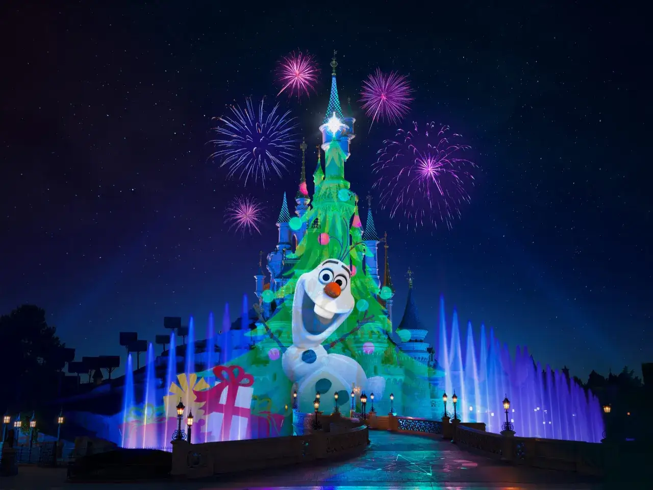Olaf feiert Weihnachten Disneyland! Ein Märchenschloss erstrahlt im Lichterglanz, Feuerwerk explodiert am Sternenhimmel, und Wasserspiele tanzen im Takt der Nacht.