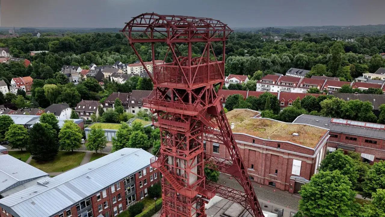 Roter Förderturm über einem Wohngebiet, ein Ort an dem einst schwarzes Gold vorkommt.