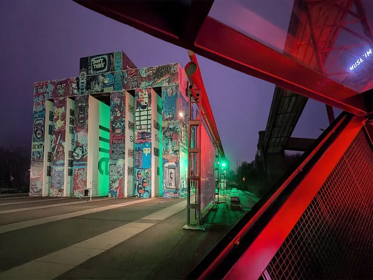 Bunte Graffiti-Kunst erhellt die Zeche Zollverein in der Nacht. Gr&uuml;ne und rote Lichter tauchen die Szenerie in ein mystisches Licht.