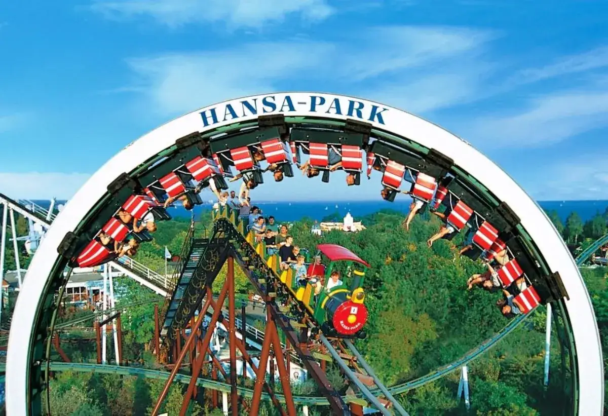 Achterbahnfahrt im Freizeitpark Hansa-Park, bei der Besucher kopf&uuml;ber durch die Luft sausen.