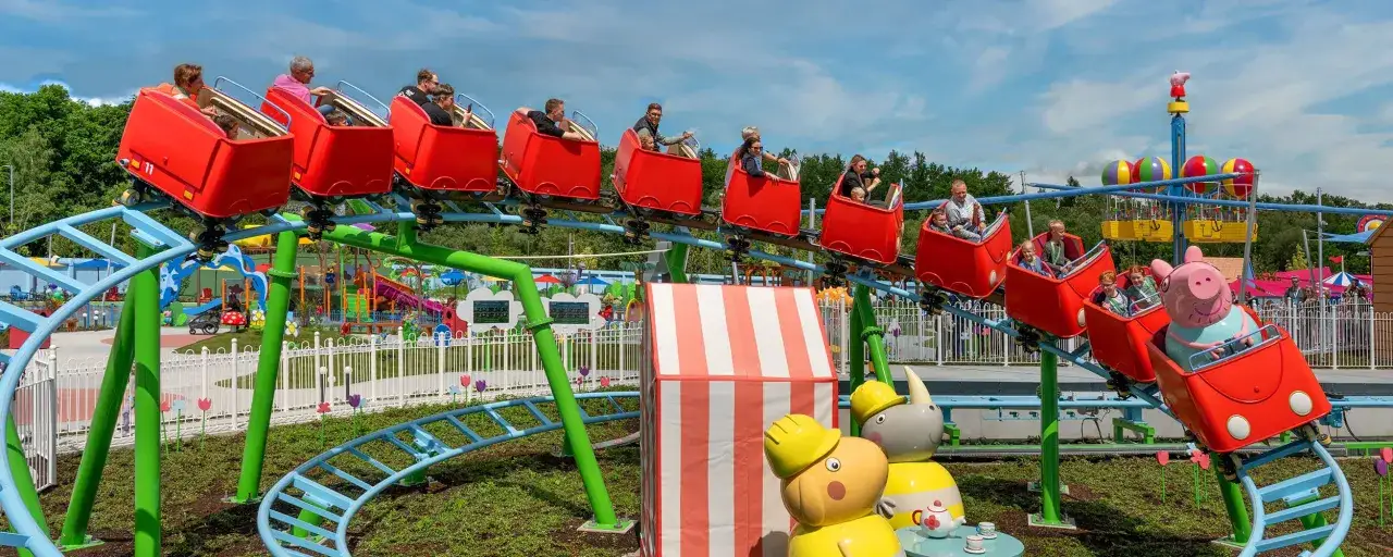Familien genießen eine Fahrt auf der Achterbahn im Legoland Peppa Pig Land.