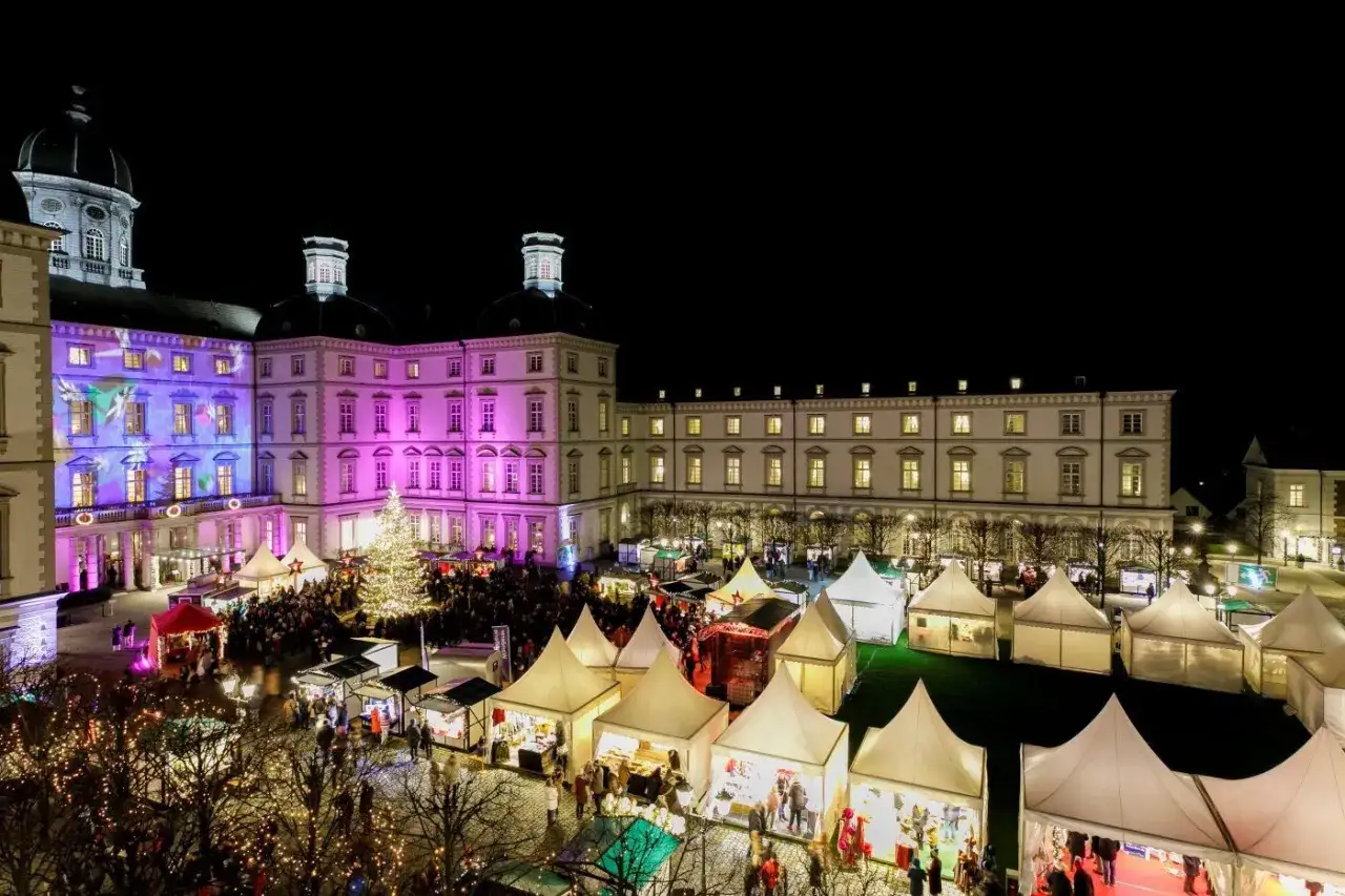 Einzigartiger Weihnachtsmarkt Bensberg vor beleuchtetem Schloss. St&auml;nde und ein Weihnachtsbaum schaffen festliche Atmosph&auml;re.