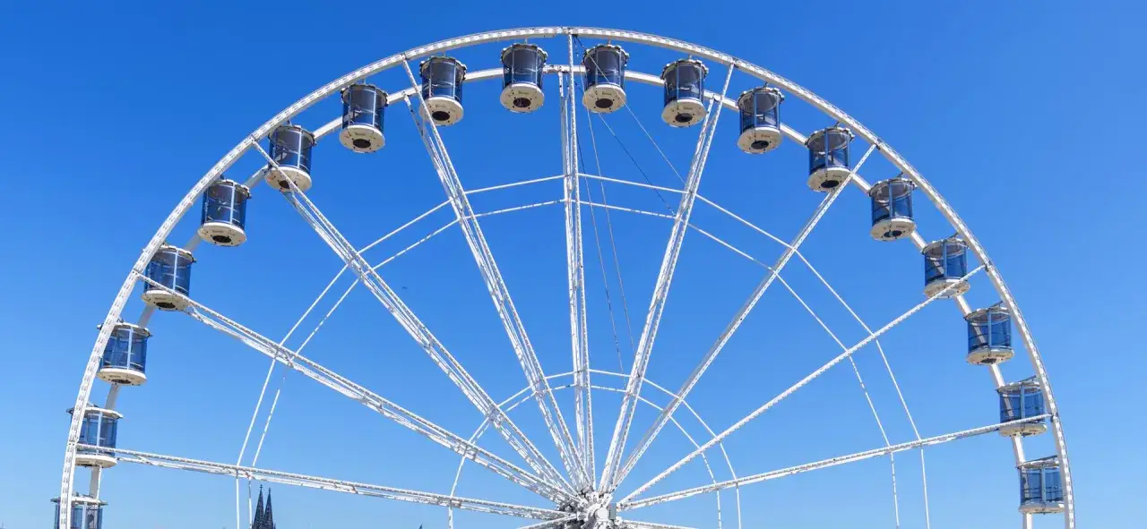 Riesenrad mit blauen Gondeln vor strahlend blauem Himmel, perfekt für das vivawest family festival.