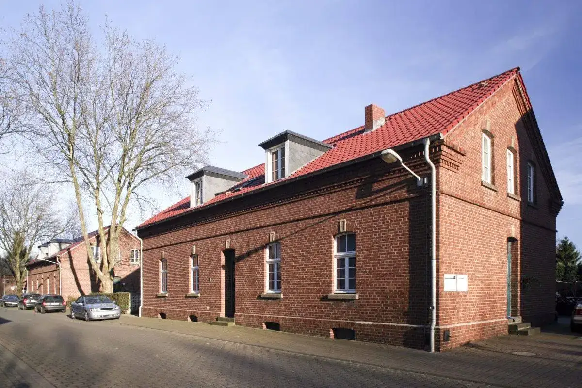 Reihenhäuser aus Backstein in Eisenheim, Oberhausen, mit roten Ziegeldächern und Mansardfenstern.