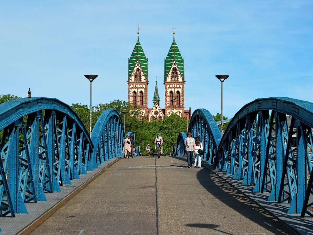Blaue Brücke in Freiburg mit Blick auf die Kirche. Hier kann man in Freiburg spazieren, Rad fahren und die Aussicht genießen.