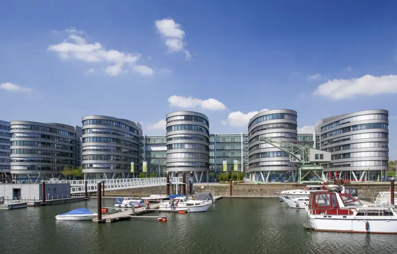 Moderne Geb&auml;ude am Duisburg Innenhafen mit Yachten im Wasser.