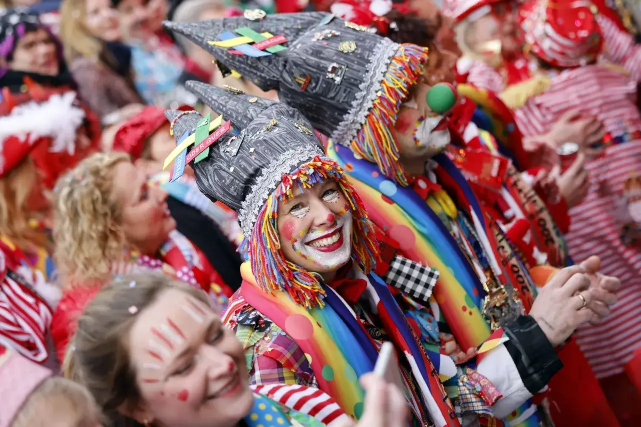 Menschen in bunten Kostümen und Clown-Make-up feiern ausgelassen. Die fröhliche Stimmung bei diesen jecken Tagen ist ansteckend.