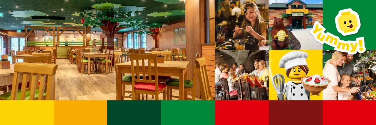 Ein gemütliches Legoland Restaurant mit Baumdeko und Familien beim Essen. Ein Lego-Koch hält einen Kuchen. Yummy!