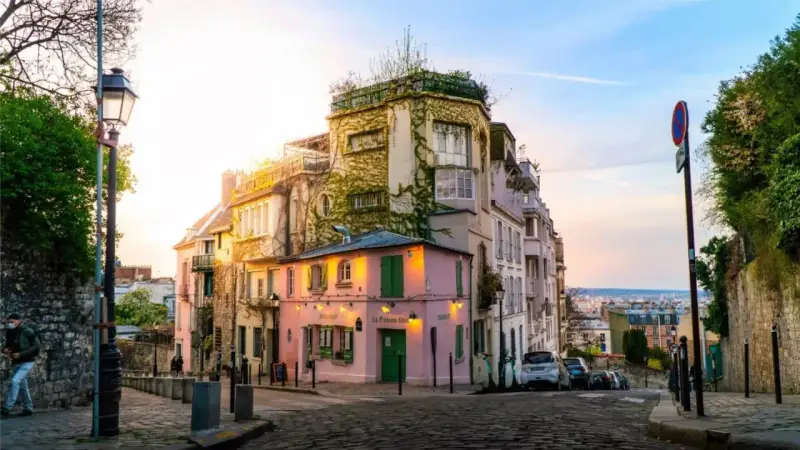 Charmante Gasse in Montmartre, Paris. Ein rosa Restaurant mit grünen Fensterläden. Tolle Paris Tipps für deinen nächsten Besuch!